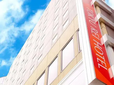 a building with a red sign on the side of it at Shibuya Tokyu REI Hotel in Tokyo