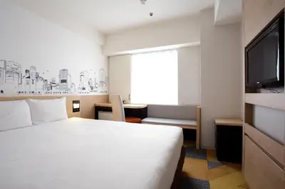a hotel room with a bed and a flat screen tv at Shibuya Tokyu REI Hotel in Tokyo