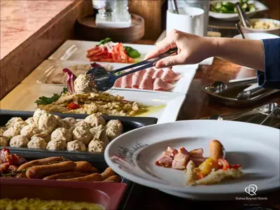 a person is serving food at a buffet at Daiwa Roynet Hotel Tokyo Osaki in Tokyo