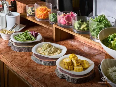 a counter with plates of food and bowls of vegetables at Daiwa Roynet Hotel Tokyo Osaki in Tokyo