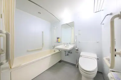 a white bathroom with a toilet and a sink at Daiwa Roynet Hotel Tokyo Osaki in Tokyo
