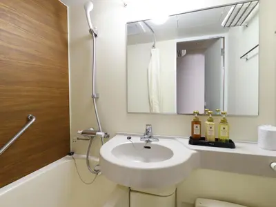 a bathroom with a sink and a mirror at Dormy Inn Tokyo Hatchobori - Natural Hot Spring in Tokyo