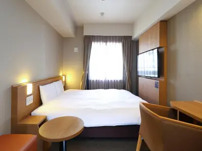 a hotel room with a bed and a window at Dormy Inn Tokyo Hatchobori - Natural Hot Spring in Tokyo
