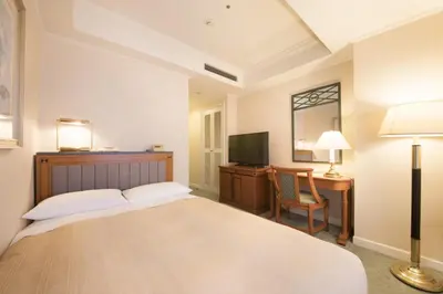 a bedroom with a bed and a desk and a television at Hotel East 21 Tokyo in Tokyo