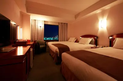 a hotel room with two beds and a window at Hotel East 21 Tokyo in Tokyo