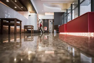 a person walking through a lobby with a shiny floor at the b suidobashi in Tokyo
