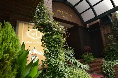 a sign on the side of a building with plants at Sakura Fleur Aoyama in Tokyo