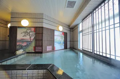 a swimming pool in a building with windows at Dormy Inn Express Meguro Aobadai Hot Spring in Tokyo