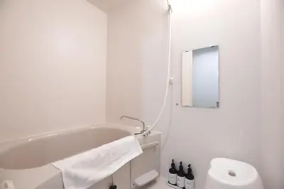 a white bathroom with a tub and a mirror at Randor Residence Tokyo Suites in Tokyo
