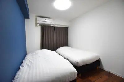 a small room with two beds and a window at Randor Residence Tokyo Suites in Tokyo