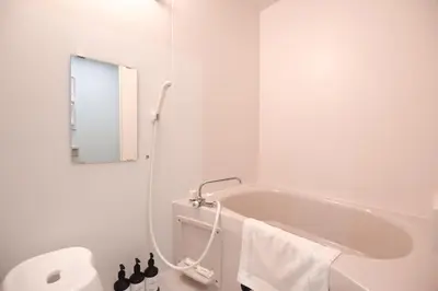 a white bathroom with a tub and a mirror at Randor Residence Tokyo Suites in Tokyo