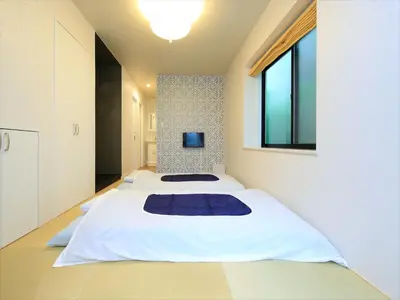 two beds in a room with a window at COTO Tokyo Shibuya 2 in Tokyo