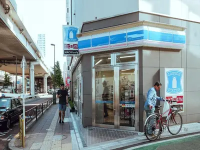 a man on a bike in front of a store at COTO Tokyo Shibuya 2 in Tokyo