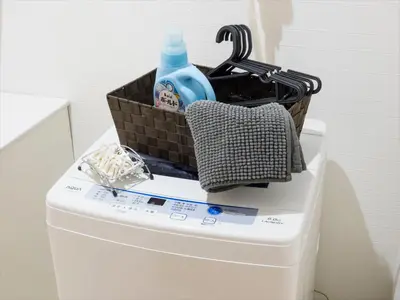 a basket on top of a toilet tank with a bottle at COTO Tokyo Shibuya 2 in Tokyo