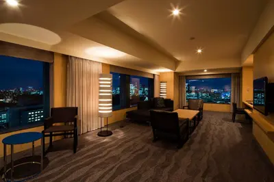 a living room with a view of a city at night at The Capitol Hotel Tokyu in Tokyo