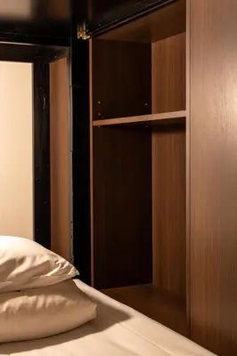 a bedroom with a book shelf and a bed at Hotel Owl Tokyo Nippori in Tokyo