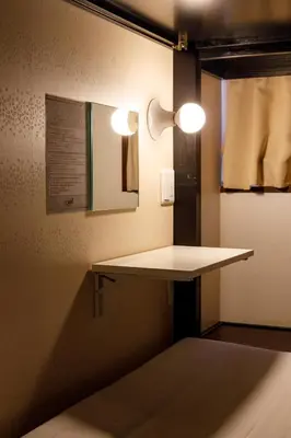 a room with a table and lights on the wall at Hotel Owl Tokyo Nippori in Tokyo