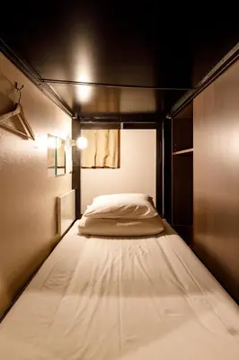 a large bed in a small room with at Hotel Owl Tokyo Nippori in Tokyo