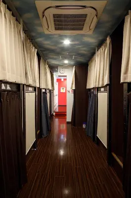 a hallway of a dressing room with curtains and wood floors at Hotel Owl Tokyo Nippori in Tokyo