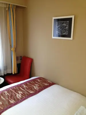 a bedroom with a bed and a red chair at Hotel Horidome Villa in Tokyo