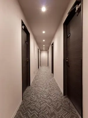 a corridor with doors and a carpeted hallway at Hotel New Tohoku in Tokyo