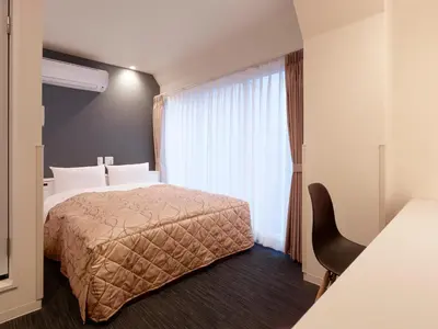 a hotel room with a bed and a window at Hotel New Tohoku in Tokyo