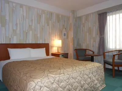 a hotel room with a bed and a table and chairs at Hotel New Tohoku in Tokyo
