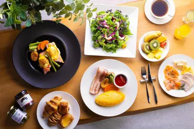 a wooden table with plates of food on it at Grand Nikko Tokyo Daiba in Tokyo