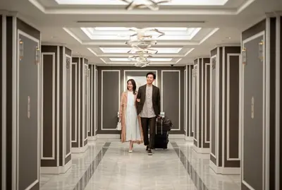 a bride and groom walking down a hallway with their luggage at Grand Nikko Tokyo Daiba in Tokyo
