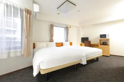 a bedroom with a large white bed and a window at HOTEL MYSTAYS Kameido in Tokyo