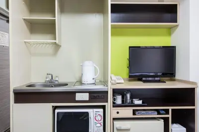 a small kitchen with a microwave and a tv at HOTEL MYSTAYS Ueno Inaricho in Tokyo