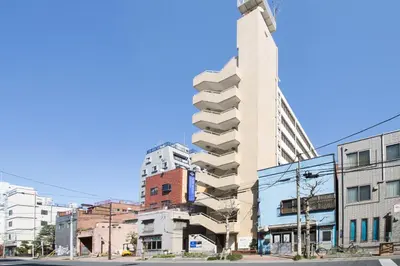 a tall building on a city street with buildings at HOTEL MYSTAYS Ueno Inaricho in Tokyo