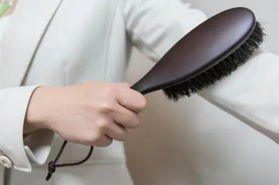 a person holding a brush in their hand at HOTEL MYSTAYS Ueno Inaricho in Tokyo