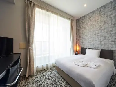 a hotel room with a bed and a large window at Sotetsu Grand Fresa Tokyo-Bay Ariake in Tokyo