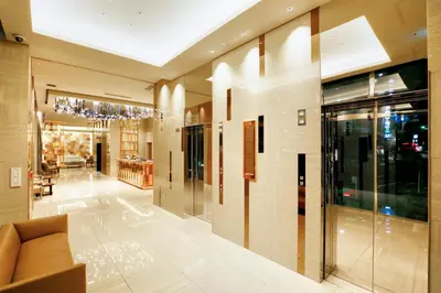 a lobby of a building with a couch and a chandelier at Candeo Hotels Tokyo Roppongi in Tokyo