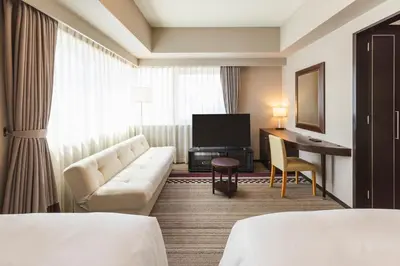 a hotel room with a couch and a television at Hotel Sunroute Plaza Shinjuku in Tokyo