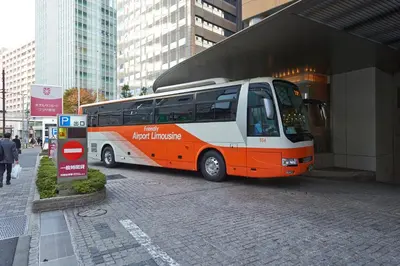 an orange and white bus parked in front of a building at Hotel Sunroute Plaza Shinjuku in Tokyo