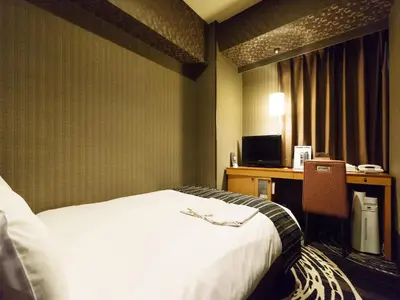 a hotel room with a bed and a desk at Sotetsu Fresa Inn Higashi Shinjuku in Tokyo