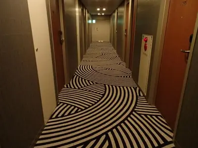 a long corridor with black and white stripes at Sotetsu Fresa Inn Higashi Shinjuku in Tokyo