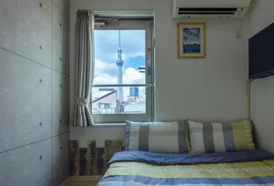 a bedroom with a bed and a window with a view at Tokyo Sakura hotel in Tokyo