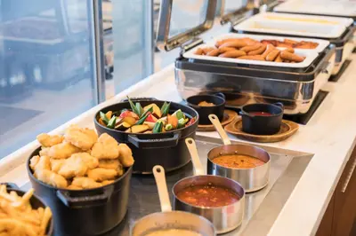 a buffet with bowls of food and other foods at Hotel Metropolitan Tokyo Marunouchi in Tokyo