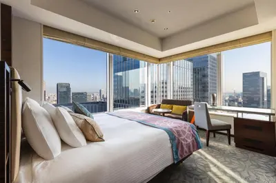a bedroom with a large bed and a large window at Hotel Metropolitan Tokyo Marunouchi in Tokyo
