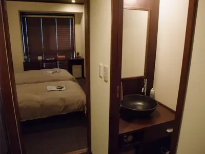 a room with a mirror and a bed and a sink at Ochanomizu Hotel Shoryukan in Tokyo