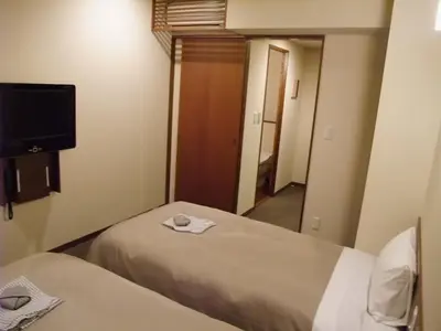 a hotel room with two beds and a tv at Ochanomizu Hotel Shoryukan in Tokyo