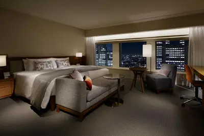 a bedroom with a bed and a chair and a window at Keio Plaza Hotel Tokyo Premier Grand in Tokyo