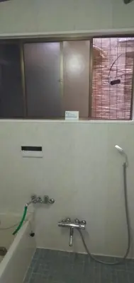 a bathroom with a bath tub with a mirror at Tama Ryokan in Tokyo