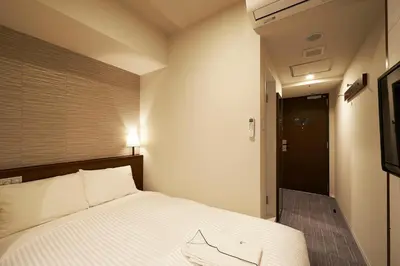 a bedroom with a bed and a television in it at Sotetsu Fresa Inn Tokyo Roppongi in Tokyo