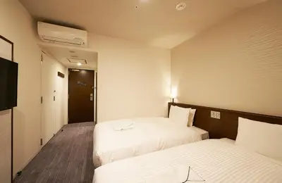 a hotel room with two beds and a television at Sotetsu Fresa Inn Tokyo Roppongi in Tokyo