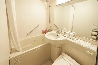 a bathroom with a sink and a toilet and a tub at Sotetsu Fresa Inn Tokyo Roppongi in Tokyo
