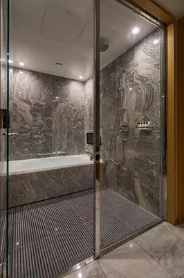 a bathroom with a shower with a stone wall at THE KITANO HOTEL TOKYO in Tokyo